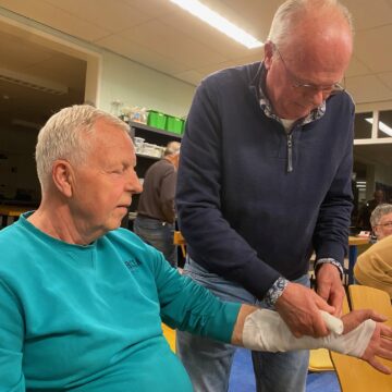 Onze voorzitter krijgt een verband aangelegd om zijn pols